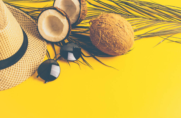Summer composition with neon lights. Tropical palm leaves, hat, glasses and broken coconut on a sandy background. The concept of the summer season, parties and heat. Flat lay, top view, copy space - Foto, Imagem