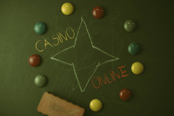 Text rukopisu Kasino Online. Koncept znamená, že hráči mohou hrát a sázet na kasinové hry prostřednictvím on-line Kulatý plochý tvar kameny s jedním gumovým lepidlem na staré křídou černé desky. - Fotografie, Obrázek