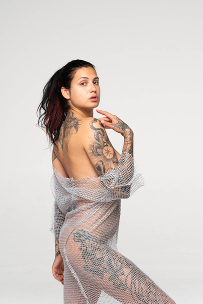 young beautiful girl with tattoo pose nude in studio - Fotoğraf, Görsel