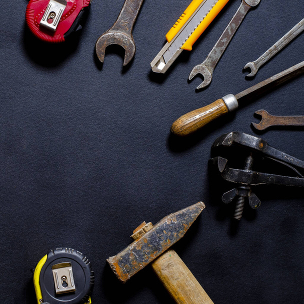 Handwerkzeuge für Reparatur und Wiederaufbau im häuslichen Umfeld liegen auf schwarzem Hintergrund. Kopierraum - Foto, Bild