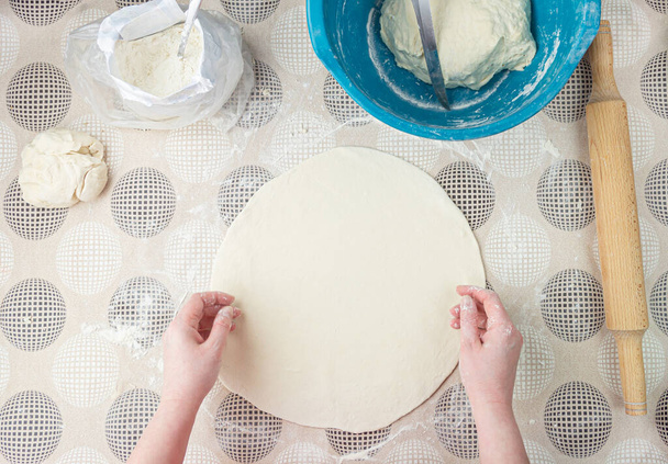 Dough with flour, rolling pin and wheat ears on rustic wooden table from above. Homemade pastry for bread or pizza. Bakery background - Photo, Image