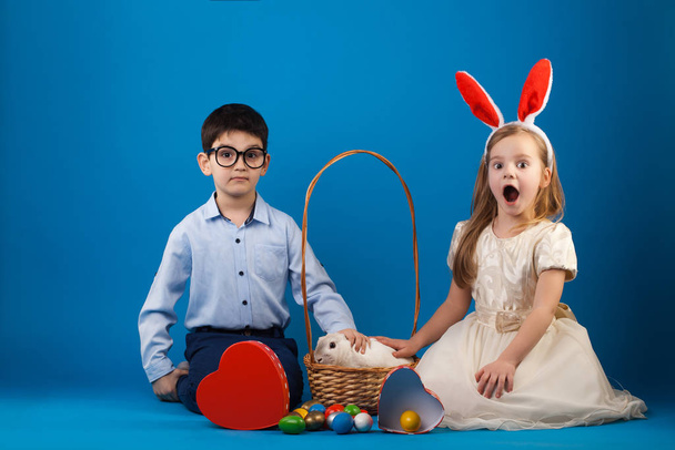 Cute boy and girl with White rabbit in basket with Easter eggs - Fotografie, Obrázek