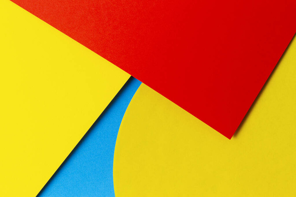 Abstraktní barevné papírové textury pozadí. Minimální geometrické tvary a linie v světle modré, červené a žluté barvě - Fotografie, Obrázek