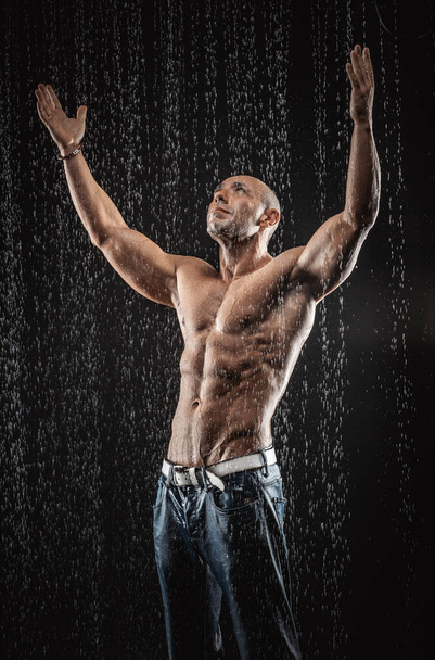 very muscular handsome athletic man in the rain - Valokuva, kuva
