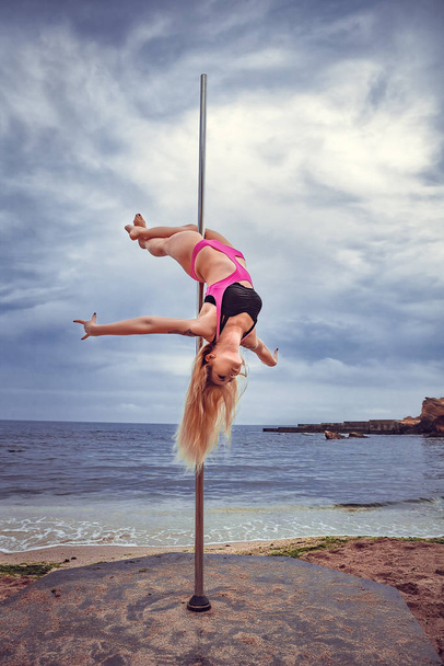 Female pole dancer against the sea and sky - Foto, Imagen