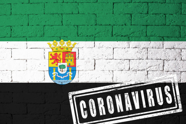 Σημαία των περιφερειών ή κοινοτήτων της Ισπανίας Extremadura με πρωτότυπες αναλογίες. σφραγίδα του Coronavirus. υφή τούβλου τοίχου. Ιός Κορόνα. Στα πρόθυρα πανδημίας COVID-19 ή 2019-nCoV. - Φωτογραφία, εικόνα