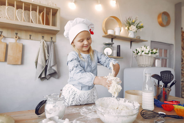 Little girl in a white shef hat cook the dough for cookies - Valokuva, kuva