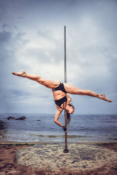 Female pole dancer against the sea and sky - Zdjęcie, obraz