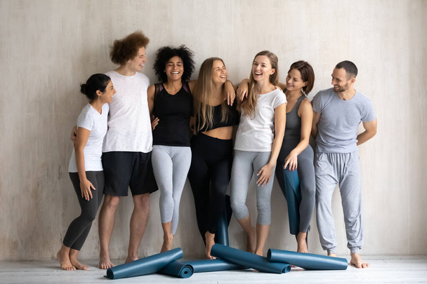 Siete personas diversas que usan ropa deportiva esperan el entrenamiento de clase de yoga
 - Foto, imagen