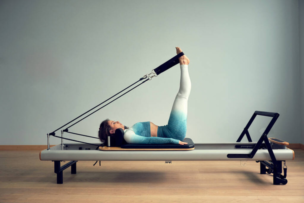 young asian woman pilates stretching sport in reformer bed instructor girl in a studio - Foto, Imagen