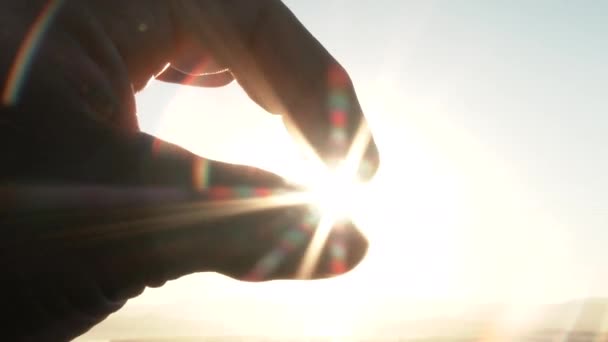 Persoon met behulp van hun vingers om de heldere en stralende ochtendzon knijpen. - Video
