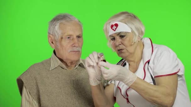 Mujer madura enfermera médico examina hombre paciente sénior con problemas
 - Metraje, vídeo