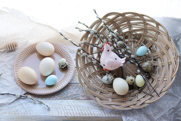 Happy Easter, a basket with painted eggs, a toy chicken on the windowsill, interior decor for the holiday  - Photo, Image