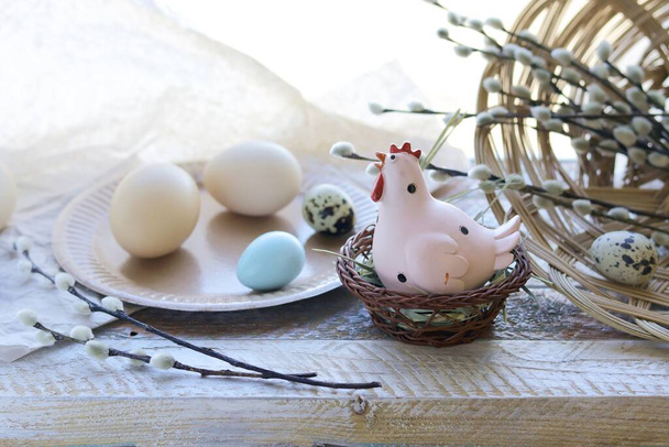 Счастливая Пасха, корзина с крашеными яйцами, игрушечная курица на подоконнике, интерьер к празднику
  - Фото, изображение