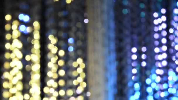 Iluminación de luz de una guirnalda de luces intermitentes en forma de bokeh de color azul, violeta y dorado. El concepto de unas vacaciones, Navidad, iluminación, fiesta
. - Metraje, vídeo