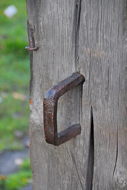Old wooden door with a steel vintage bracket, vertical frame. - Фото, изображение