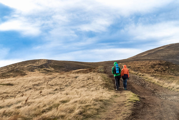 Güz. Çift backpackers sonbahar dağlarda yolda hiking. - Fotoğraf, Görsel