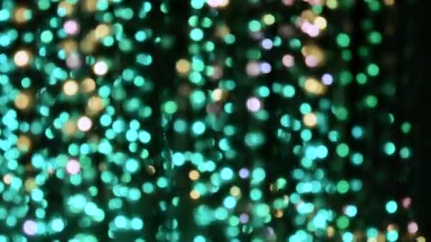 Light illumination from a garland of flashing lights in the form of bokeh white, turquoise, red, yellow and purple. The concept of a holiday, Christmas, illumination, party. - Footage, Video