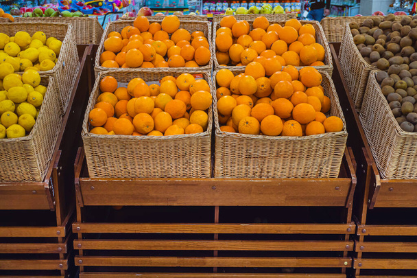 Frutos cítricos frescos em cestas em uma prateleira de loja
. - Foto, Imagem