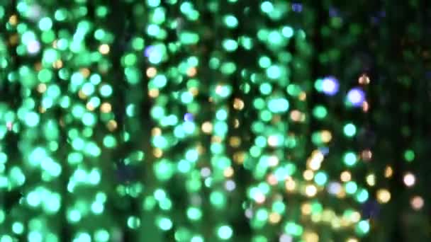 Iluminación de la luz de una guirnalda de luces intermitentes en forma de blanco bokeh, turquesa, rojo y púrpura. El concepto de unas vacaciones, Navidad, iluminación, fiesta
. - Metraje, vídeo