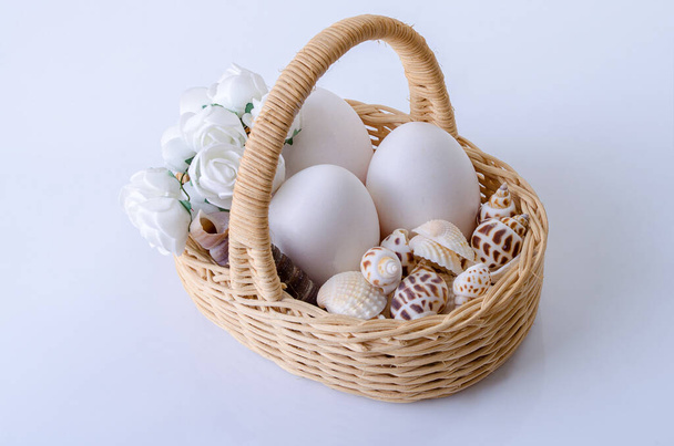 Basket of vines with chicken eggs on a gray background - Foto, Bild