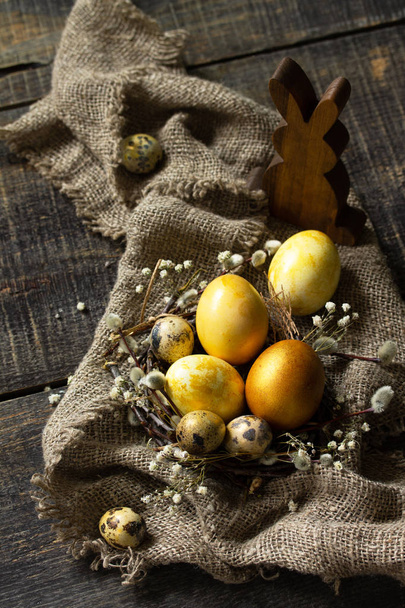 Easter eggs on wooden background. Gold handmade easter eggs in a basket. - Fotografie, Obrázek