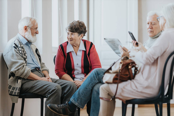 Deux personnes âgées parlent dans une file d'attente au cabinet du médecin dans une clinique
 - Photo, image