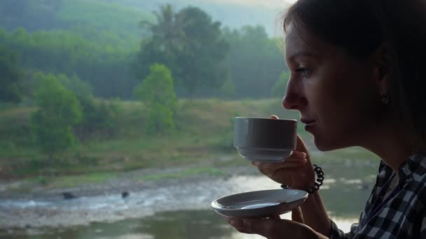 Woman drinks coffee in jungle - Záběry, video