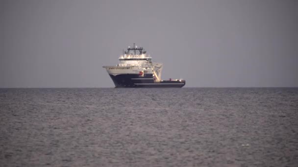 Egy hajó áll a part mellett, a nyílt tengeren, az óceánon, nyáron. Limassol, Ciprus, 4k - Felvétel, videó