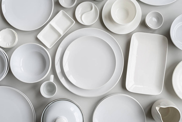 pilhas de pratos de cerâmica branca e mesa vista superior sobre fundo cinza
 - Foto, Imagem