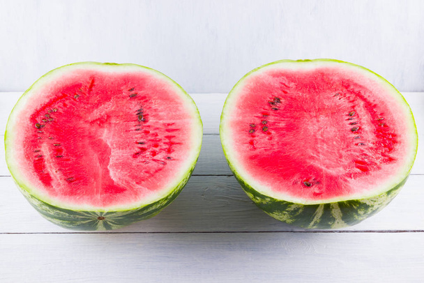 Half of watermelon on white background. Sliced watermelon on wooden boards. Healthy food for vegan. Top view - Foto, afbeelding