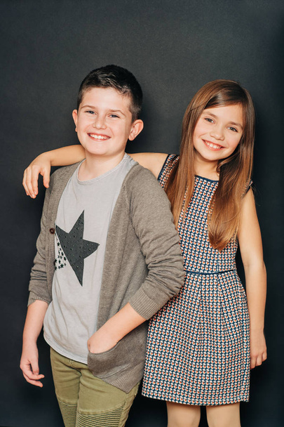 Studio portrait of two cute kids, posing on black background - Zdjęcie, obraz