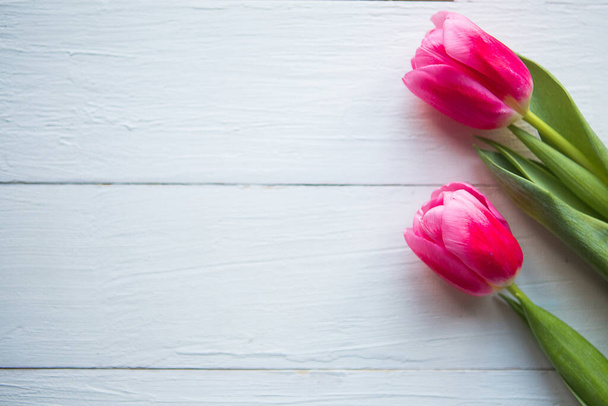 Pink tulips on wooden background. Flat lay, top view, copy space. Easter or Mother's Day greeting card - Fotografie, Obrázek