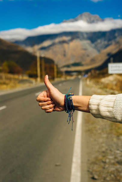Woman's hand in hitch hiking sign to ask for a car as passenger. - Photo, Image