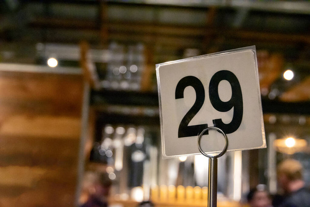 Ламінований номер 29 Twentynine Table Marker в незрозумілому ресторані
 - Фото, зображення