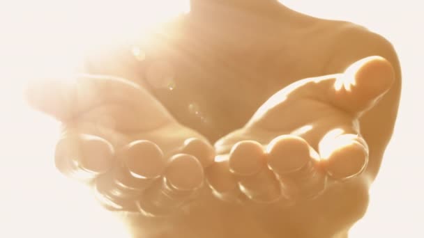 Bright heavenly light shines across person's stretched out hands close up in 4K. - Footage, Video