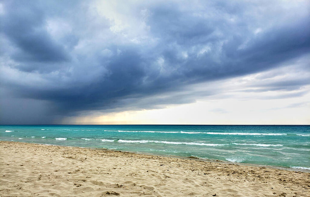 Próxima tormenta en una playa carrebia. Clima nublado y cielos, agua azul y vista saned blanco
. - Foto, imagen