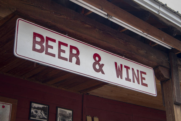 赤と白のビールとワイン地元のビジネスの木製の垂木からぶら下がっている看板 - 写真・画像