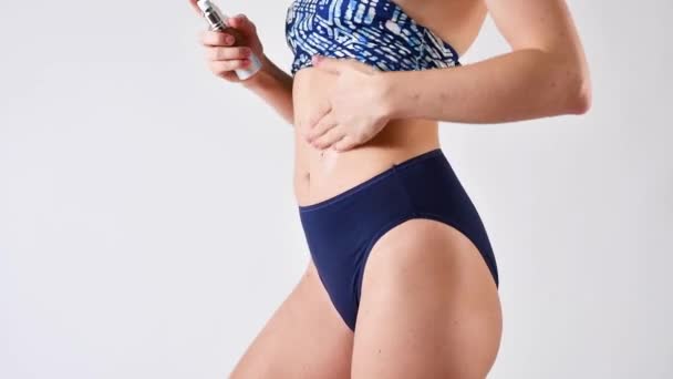 Huidverzorging en anti cellulitis crème. vrouw met perfect lichaam aanbrengen vochtinbrengende lotion op haar been - Video