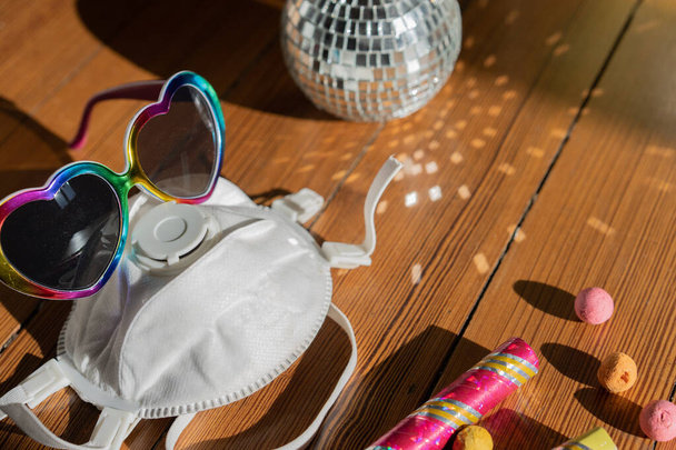 Party glóbus a sluneční brýle s ochranou masky v croud lidí v době chřipky. Koncept, detailní záběr. - Fotografie, Obrázek