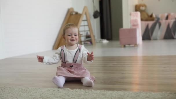 Laughing cute little infant girl playing with ball at home carpet having fun - Materiał filmowy, wideo