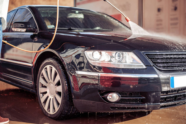 De cerca. Hombre adulto lavar su coche en lavado de coches
. - Foto, Imagen