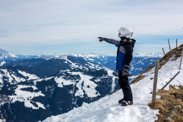 Child, skiing in winter ski resort on a sunny day, enjoying scenery landscape - Photo, image