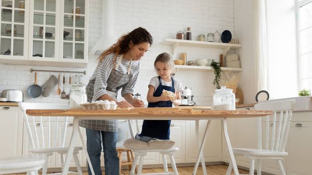 Caring mother and small daughter baking together - Valokuva, kuva