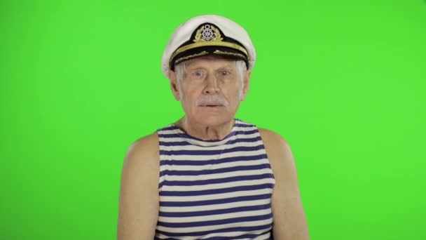 Elderly sailor man is angry and shows a fist. Sailorman on chroma key background - Záběry, video