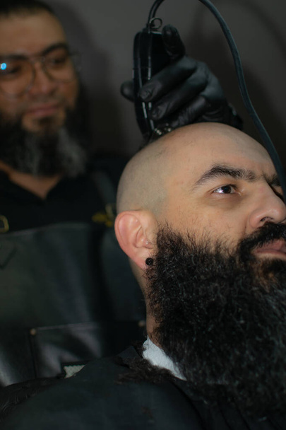 een Latijns-Amerikaanse kapper werkt de stijl met een lange baard in de stad Bogota - Foto, afbeelding