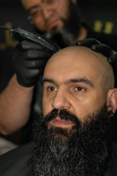 un coiffeur latino-américain travaillant le style avec une longue barbe dans la ville de Bogota
 - Photo, image