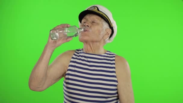 Elderly sailor man with mustache drinks vodka. Old sailorman on chroma key - Video