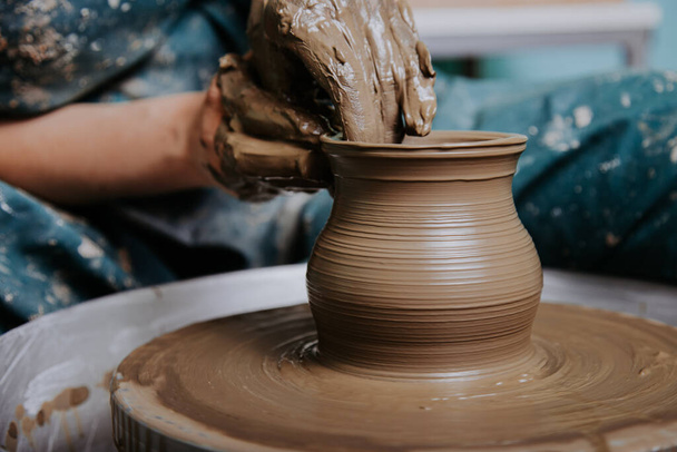 Femme mains travaillant sur la roue de poterie et de faire un pot. - Photo, image