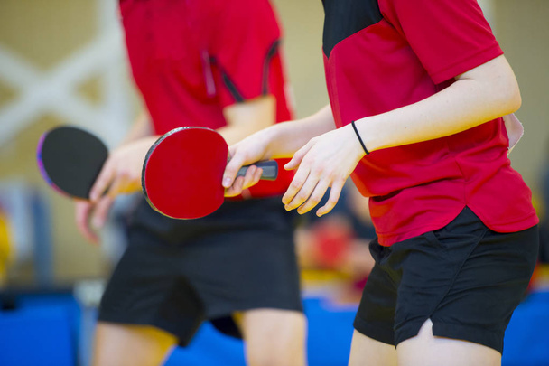 Mesa de ping pong, mujer y hombre jugando al tenis de mesa con raqueta y pelota en un pabellón deportivo
 - Foto, Imagen